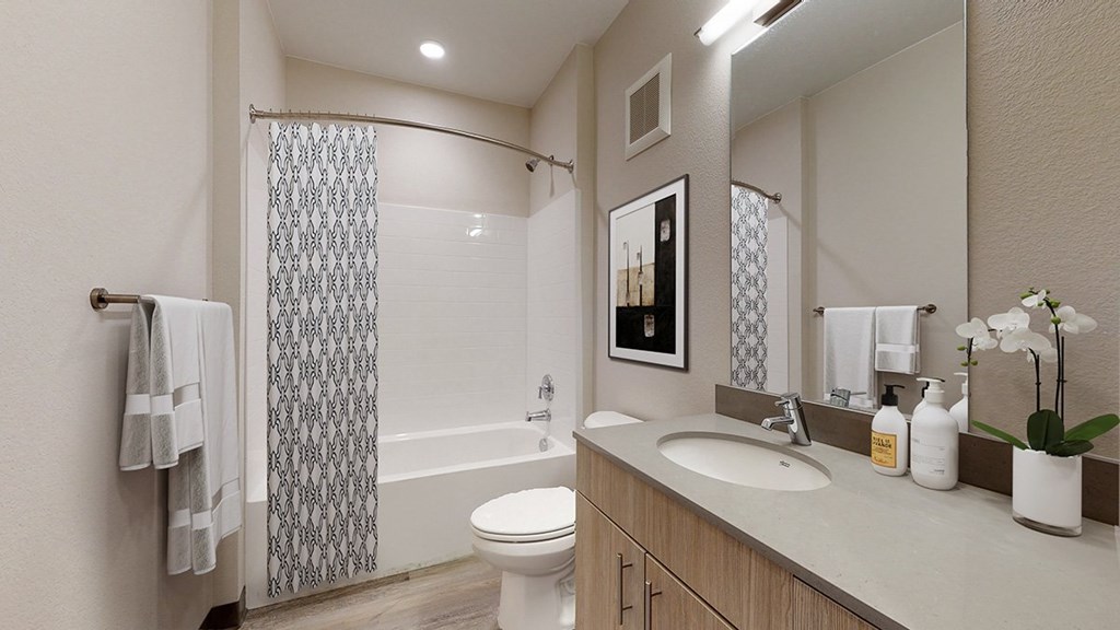 A bathroom with a toilet, sink, and shower.