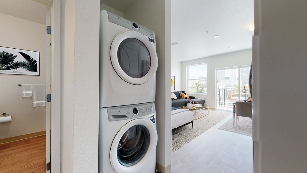 A modern laundry room with a washer and dryer stacked on top of each other.