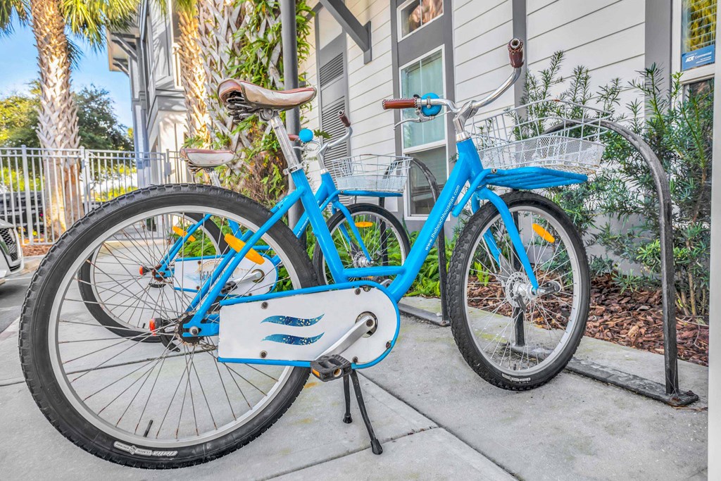two bikes parked on the sidewalk in front of a house