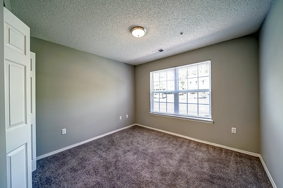 an empty room with carpet and a window
