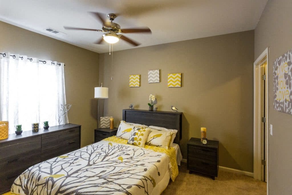a bedroom with a bed and a ceiling fan