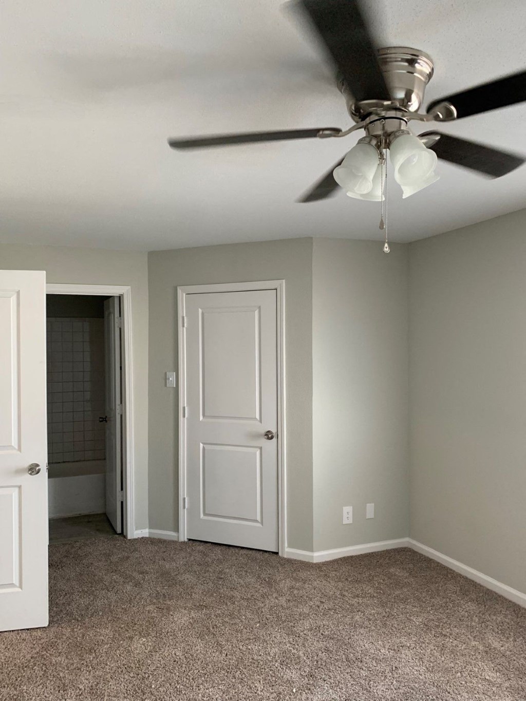 a bedroom with a ceiling fan and a closet