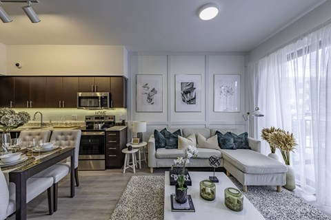A modern kitchen with a dining table and a couch in the living room.
