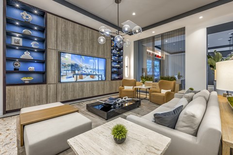 A modern living room with a large flat screen TV mounted on the wall.