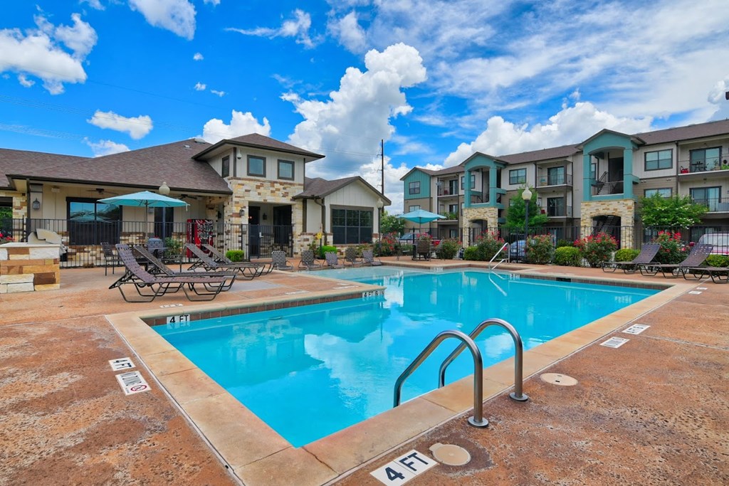 A swimming pool in front of apartment buildings.