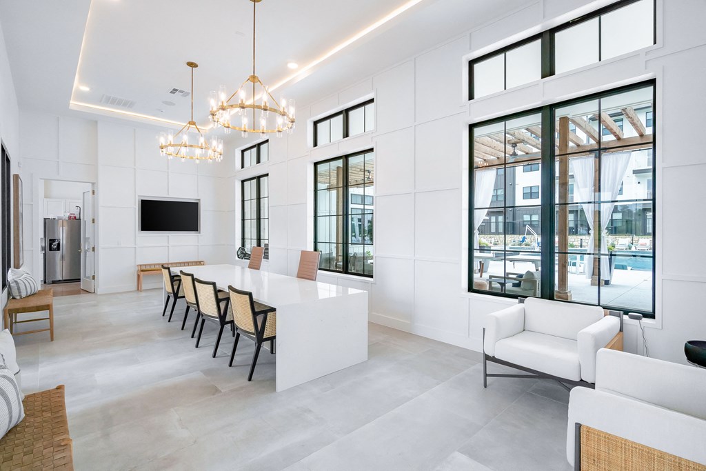 a large living room with white walls and a white table and chairs