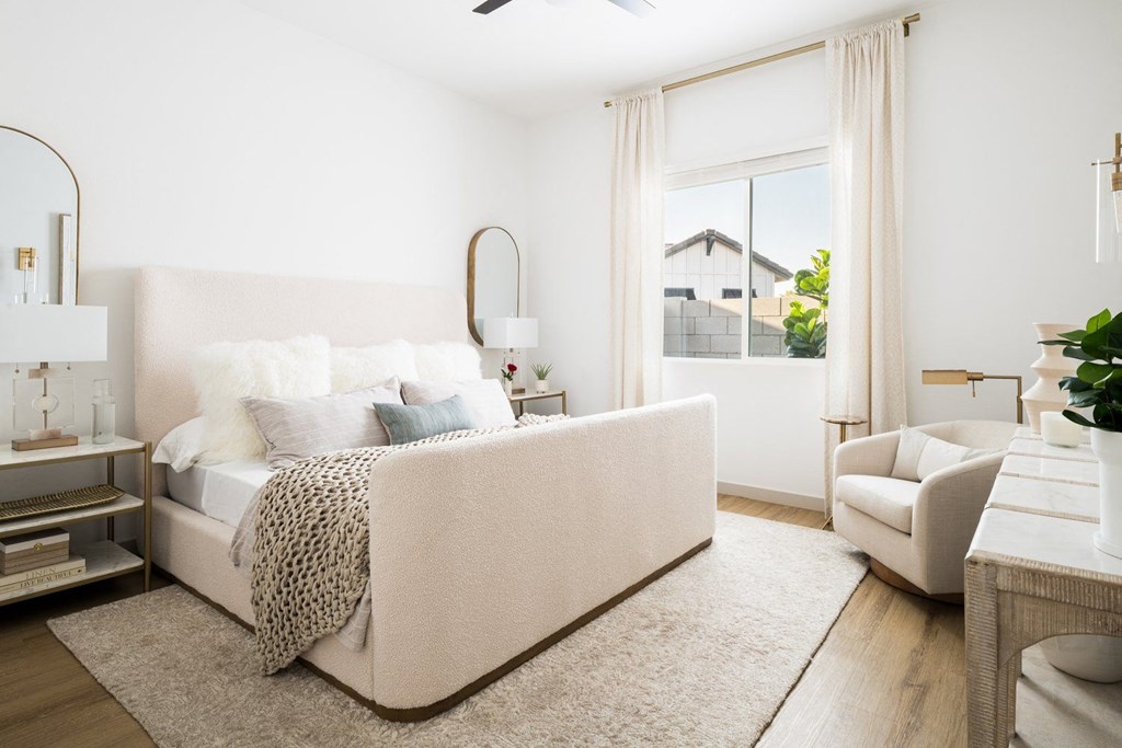 A bedroom with a large bed and a chair.