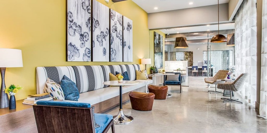 A modern living room with a striped sofa and a wooden chair.