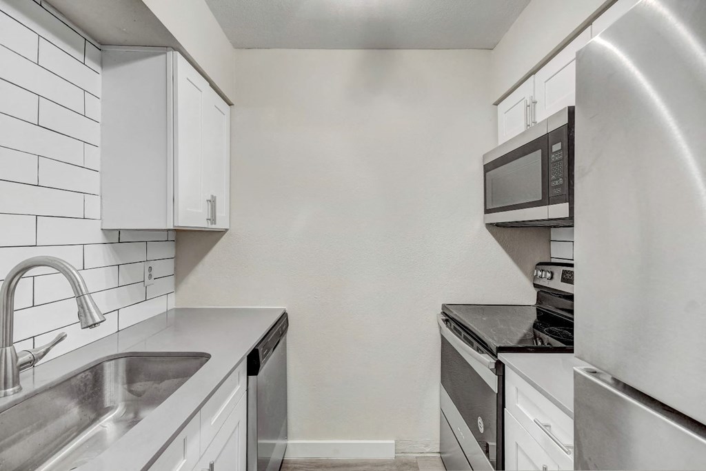 a kitchen with white cabinets and stainless steel appliances