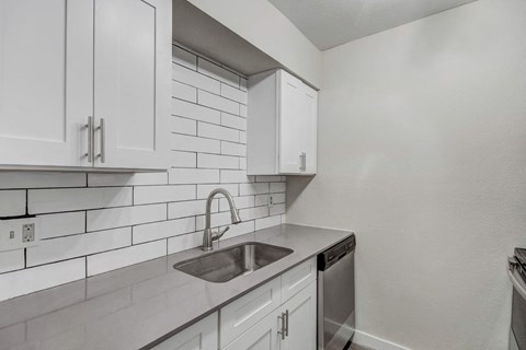a kitchen with white cabinets and a sink