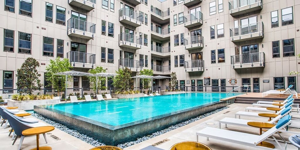 A large indoor swimming pool with lounge chairs and umbrellas.
