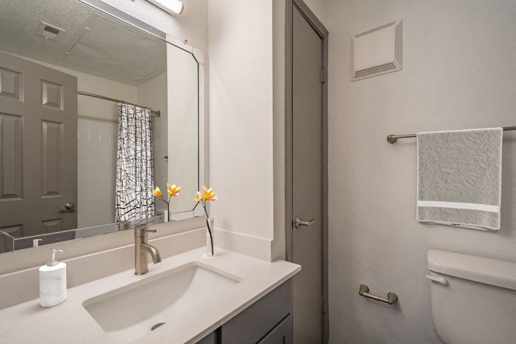 a white bathroom with a sink and a mirror