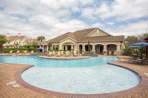 A large swimming pool in front of a house.