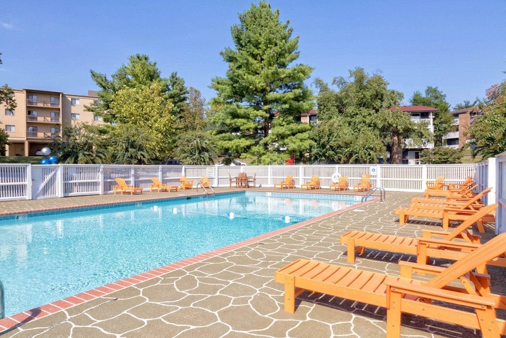 a swimming pool with wooden chairs at a resort