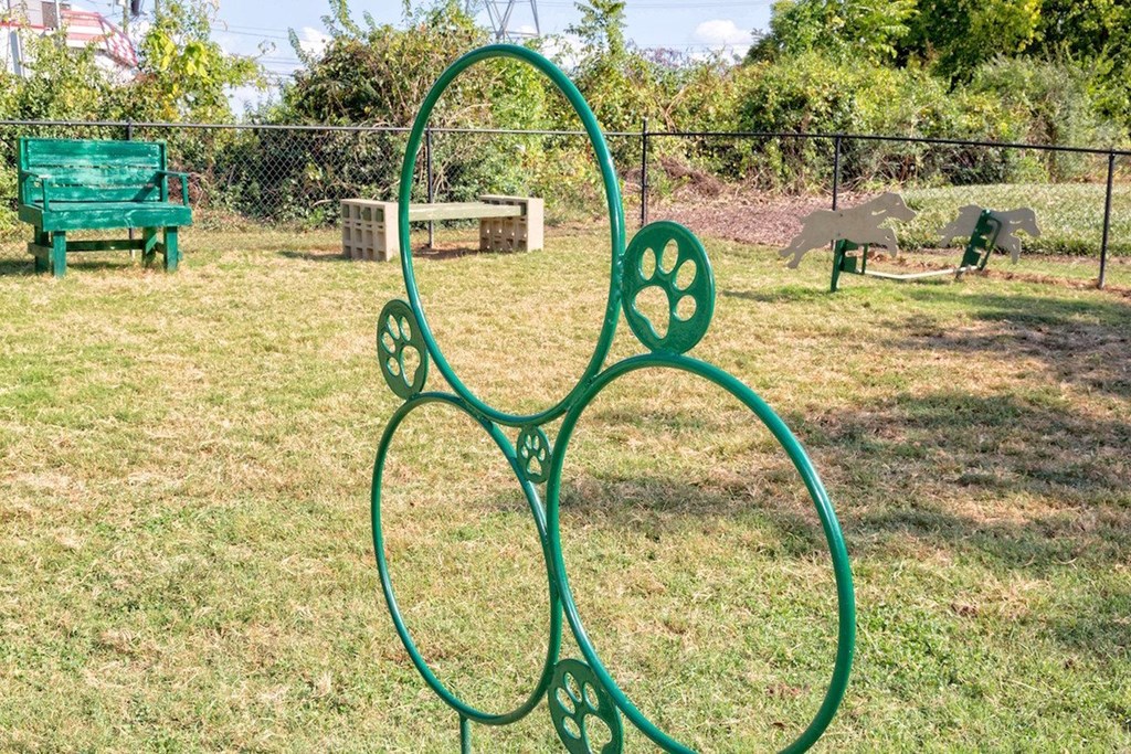 a green metal sculpture shaped like a flower in a park