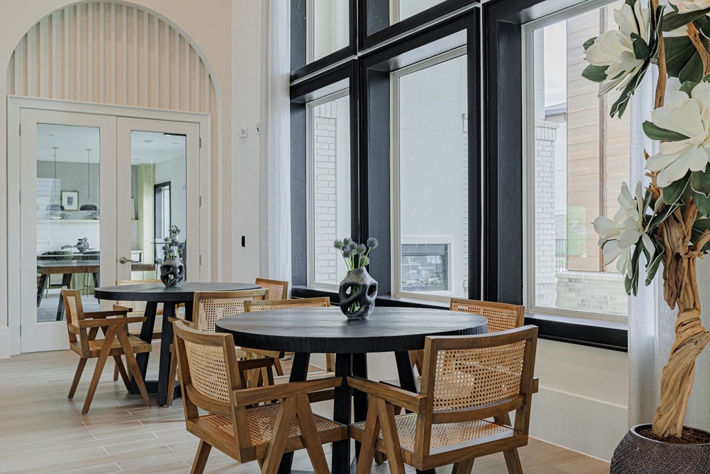 a dining area with a round table and wicker chairs