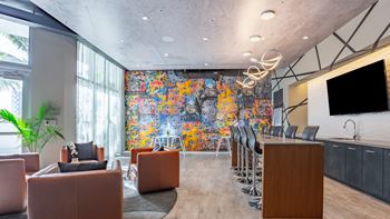 a room with a large mural on the wall and a bar in the middle of the room