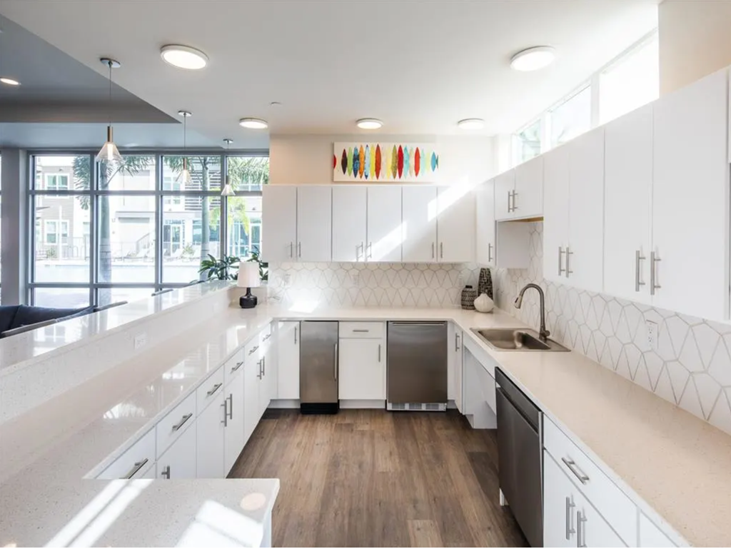 a large white kitchen with white cabinets and a large window