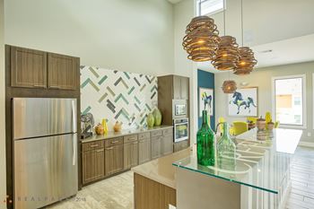 A modern kitchen with a glass counter top and wooden cabinets.