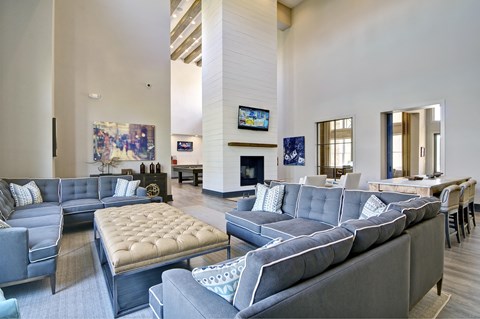 a large living room with blue couches and chairs and a fireplace