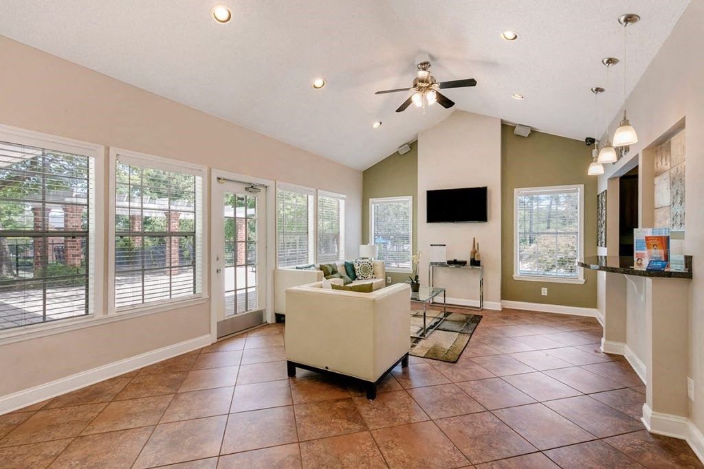 a living room with a ceiling fan and a lot of windows