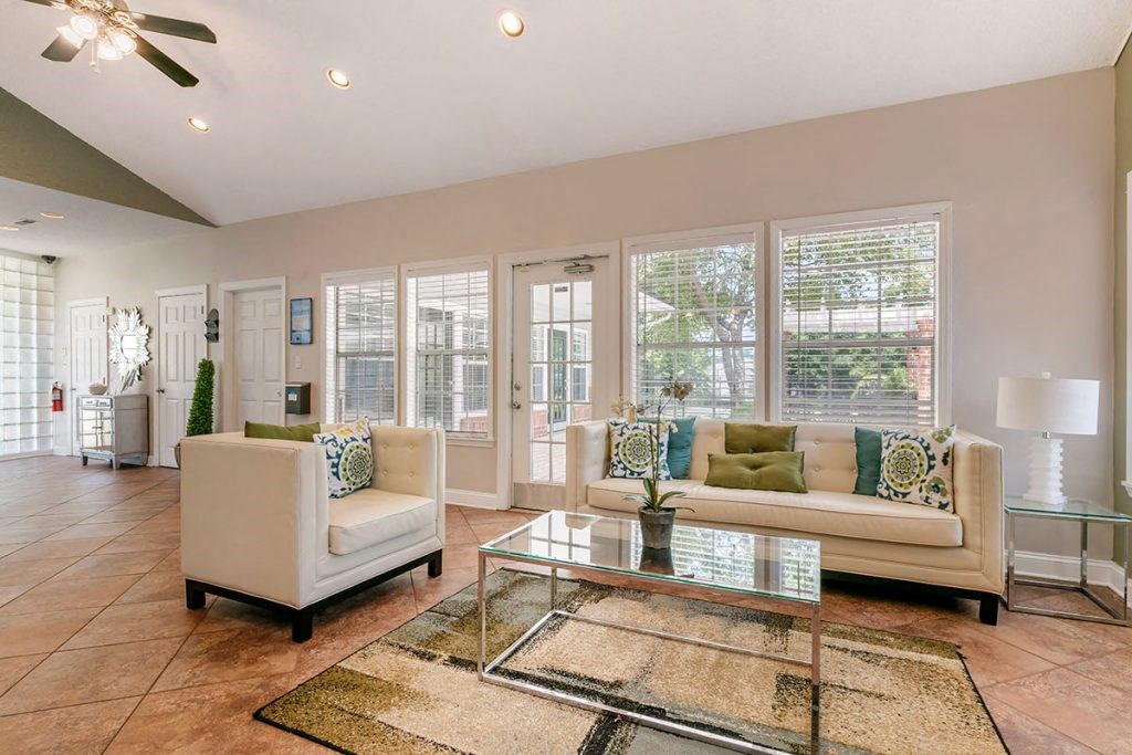 a living room with white couches and a glass coffee table