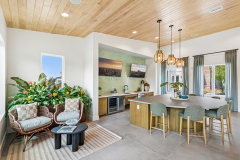 A modern kitchen with a wooden ceiling and a dining table set with chairs.