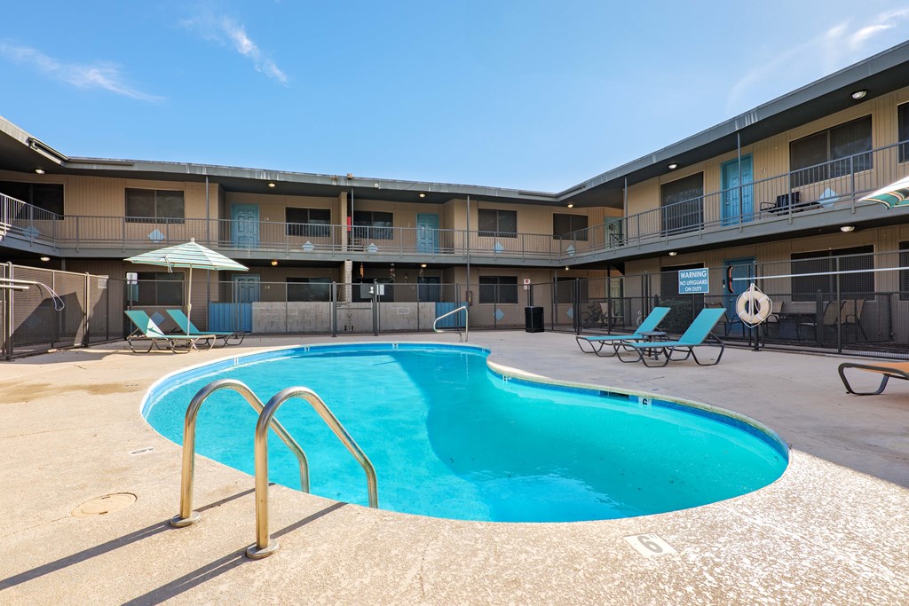 A swimming pool in a sunny outdoor pool area.