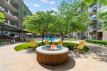 A small pool surrounded by a hot tub and chairs.