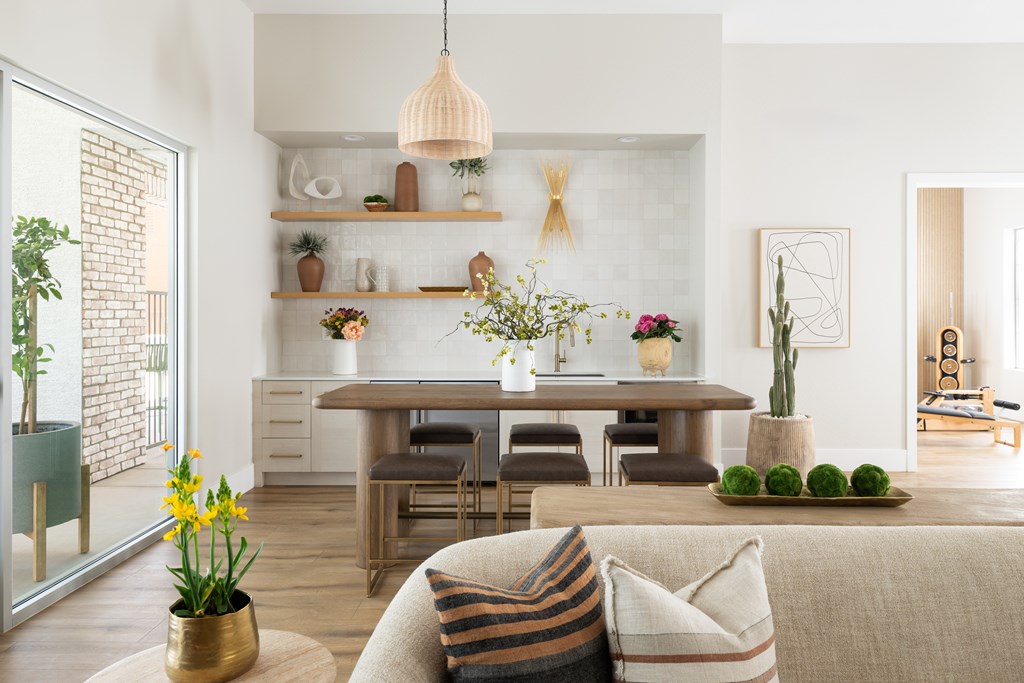 A living room with a couch, a table, and a potted plant.