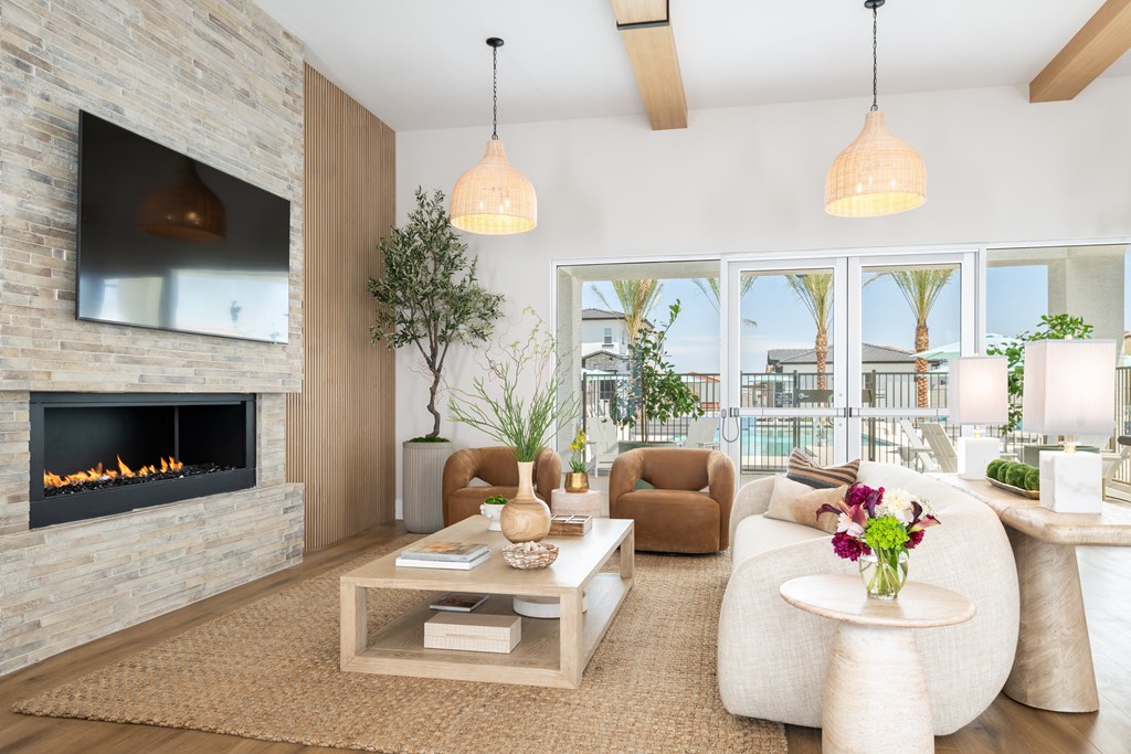 A modern living room with a stone fireplace and a flat screen TV.
