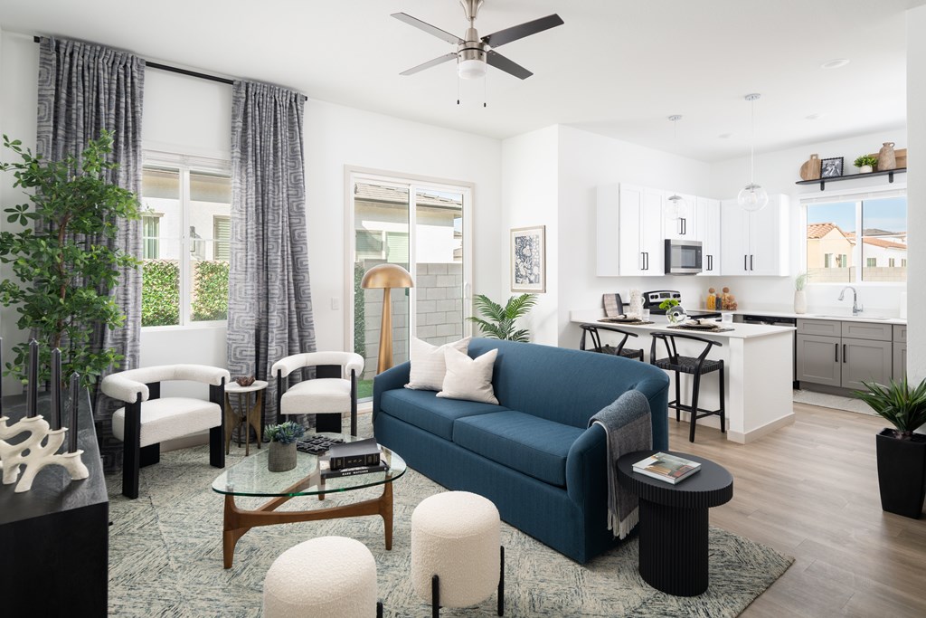 A living room with a blue couch and a glass table.