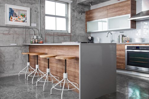 a kitchen with wooden bar stools and a stainless steel counter