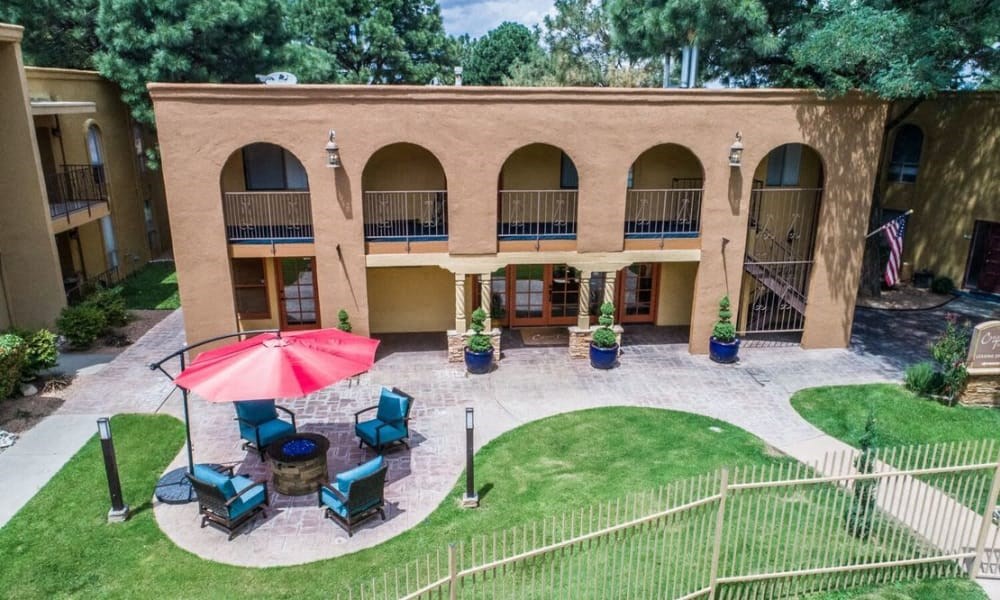 an aerial view of the courtyard of a building with chairs and an umbrella