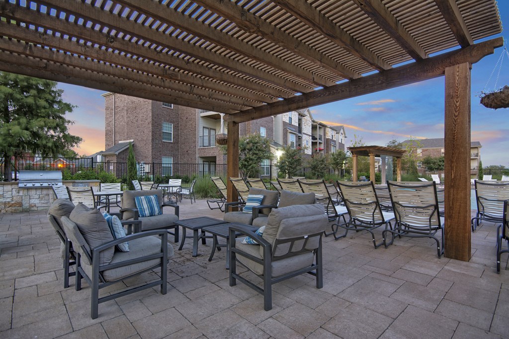 an outdoor patio with tables and chairs and a pergola