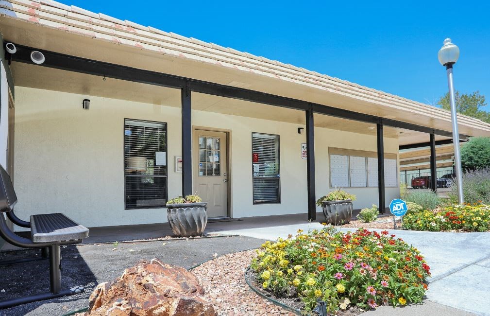 a building with a bench and flowers in front of it
