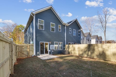 A blue house with a wooden fence in front.