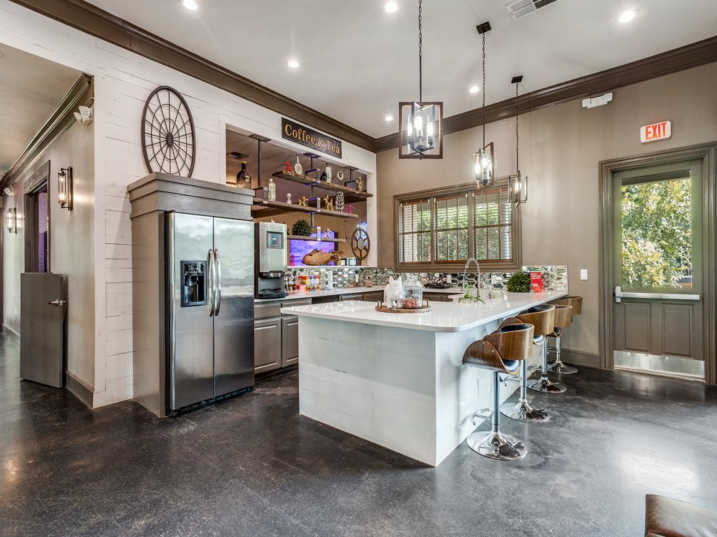 A modern kitchen with a large island and stainless steel appliances.