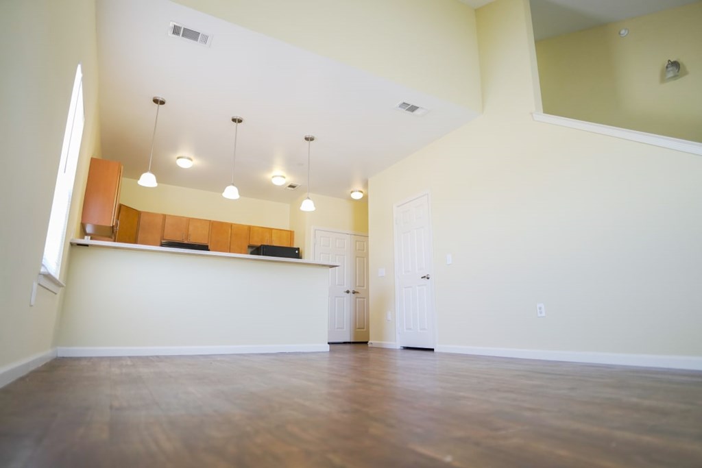 A large empty room with a counter and a door.