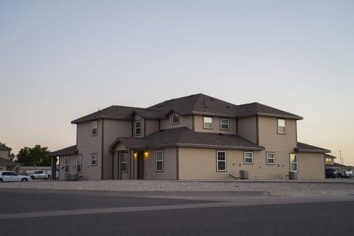 A large house with a grey roof and a brown exterior.