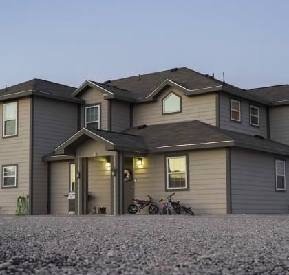 A house with a garage and a motorcycle parked outside.