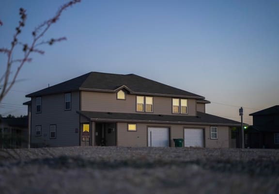 A house with a garage and a driveway in front.