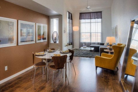 a dining room with a table and chairs and a living room in the background