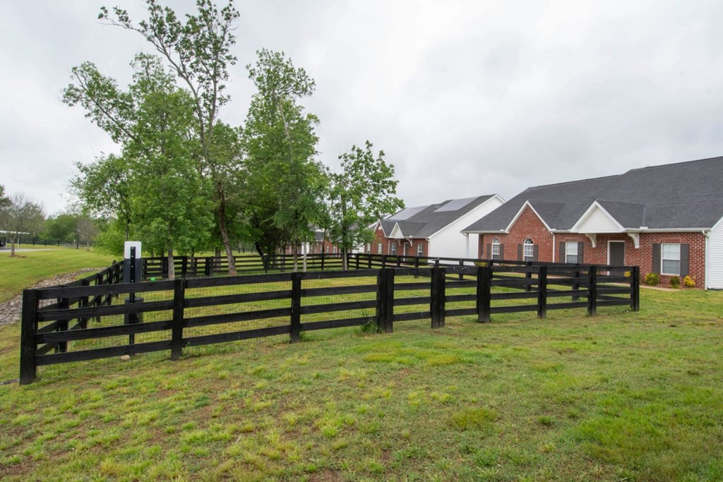 A black fence in front of a red brick house.
