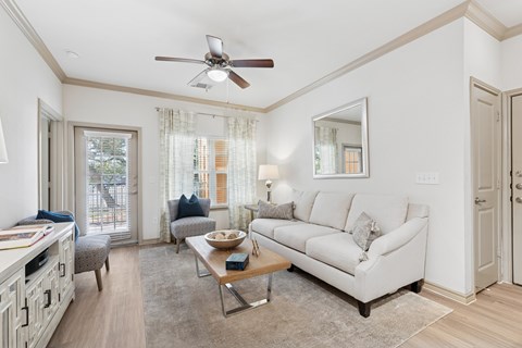 A living room with a white couch and a ceiling fan.