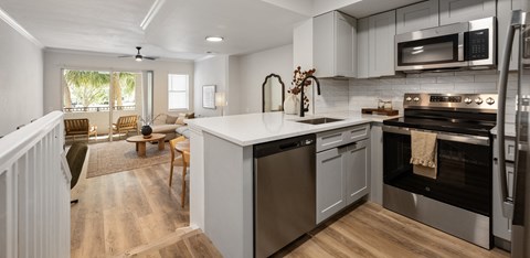 A modern kitchen with a stainless steel oven and a wooden floor.