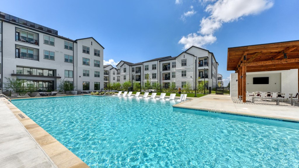 an outdoor swimming pool with apartments in the background