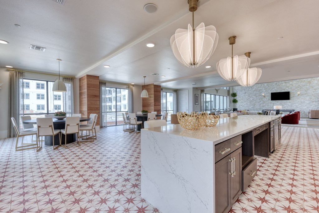 a large kitchen with a marble counter top and a dining room