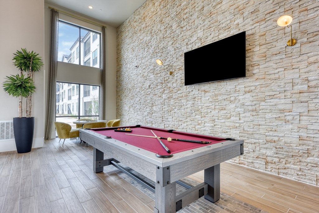 a billiards table in a clubhouse with a tv on the wall
