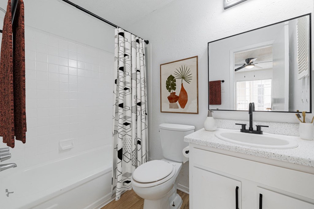 a bathroom with a shower and a toilet and a sink